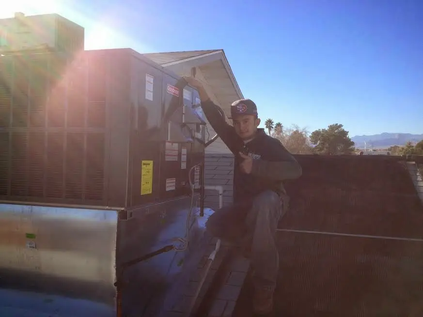 HVAC technician performing AC Tune-Up on a rooftop unit in Purcellville